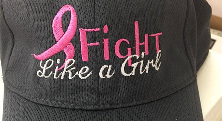 a hat with an embroidery design on it that says Fight like a girl